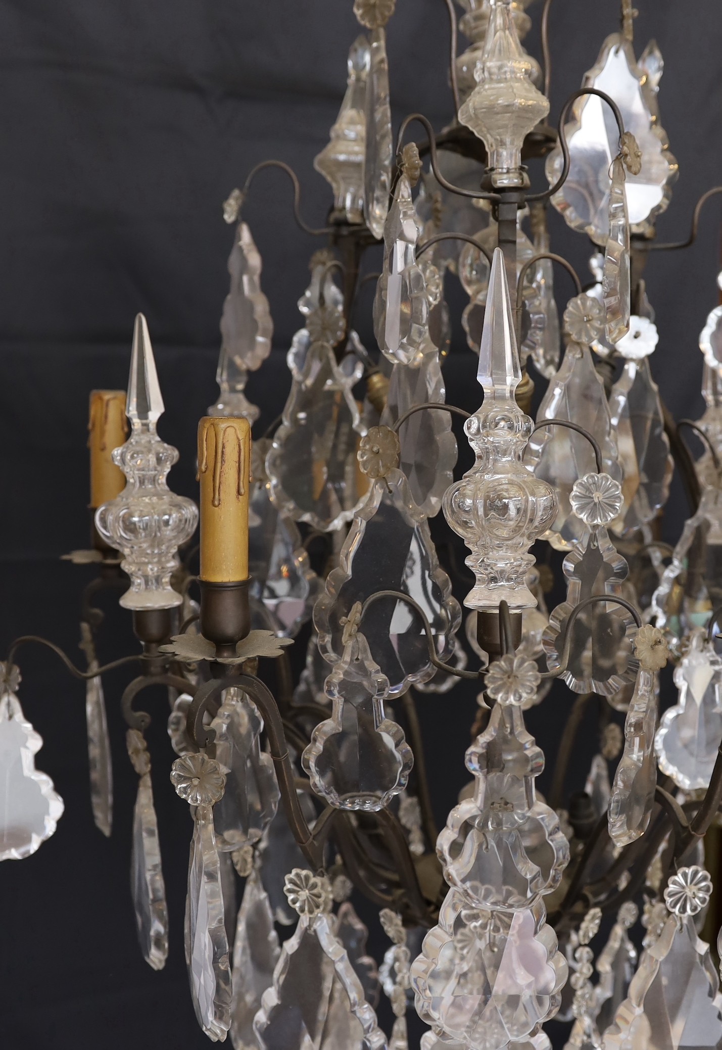 An early 20th century French bronze and cut glass six light chandelier, of particularly ornate design with spear finials, lozenge shaped drops and flower head motifs, height 101cm. width 60cm